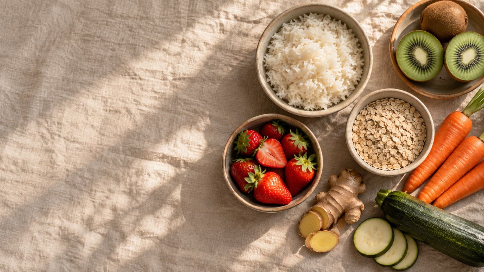 Arroz, kiwi, morangos, aveia, cenoura e abobrinha sobre linho claro